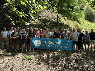 Photo de groupe de la visite du 23 juillet 2026 : chasseurs de Haute-Loire et techniciens de la FDC Isère, banderole Région Auvergne-Rhône-Alpes