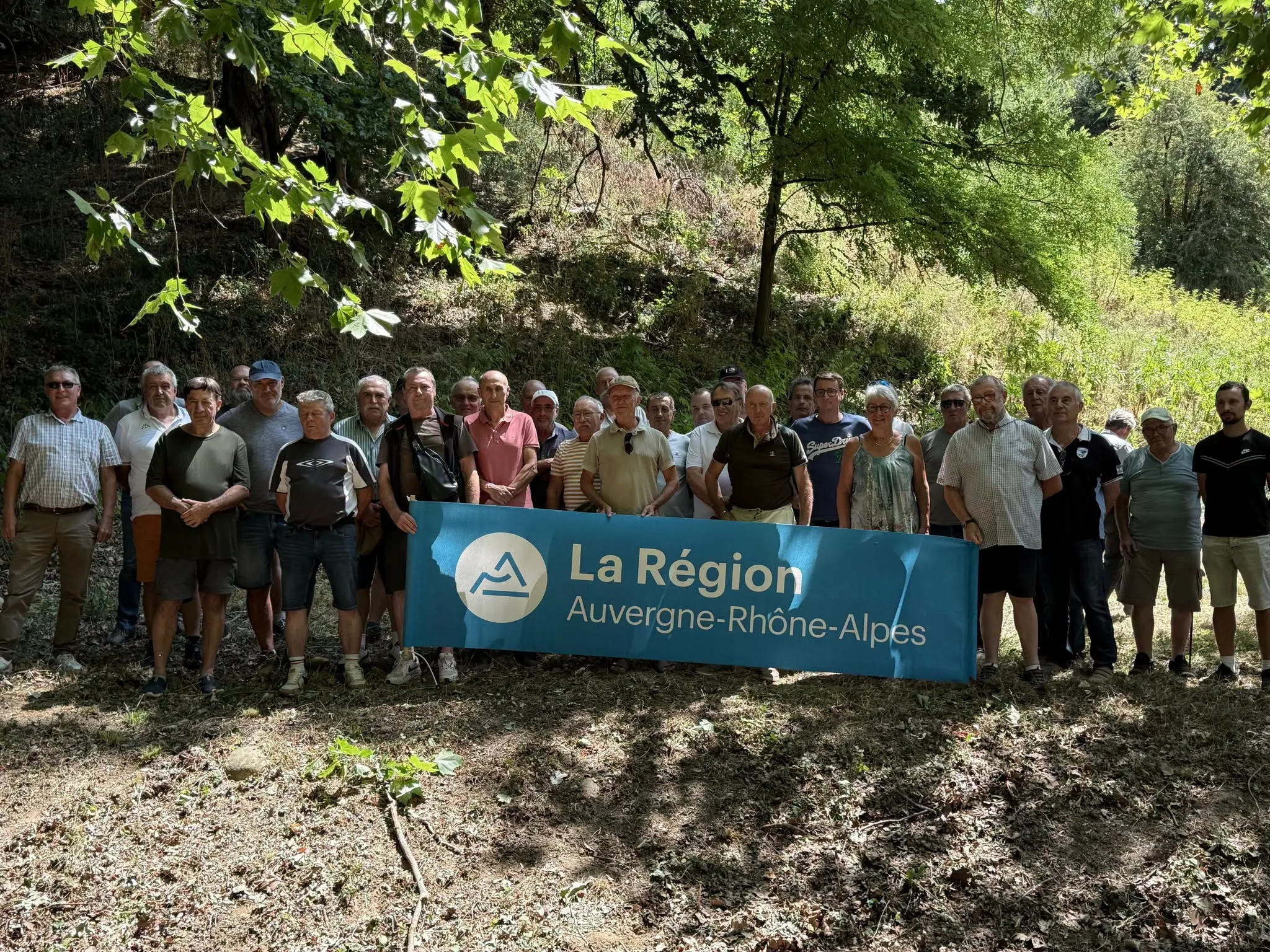 Photo de groupe des chasseurs de Haute-Loire (24 ACCA) en visite en Isère le 23 juillet 2026, banderole Région Auvergne-Rhône-Alpes — photo Fédération Départementale des Chasseurs de l'Isère